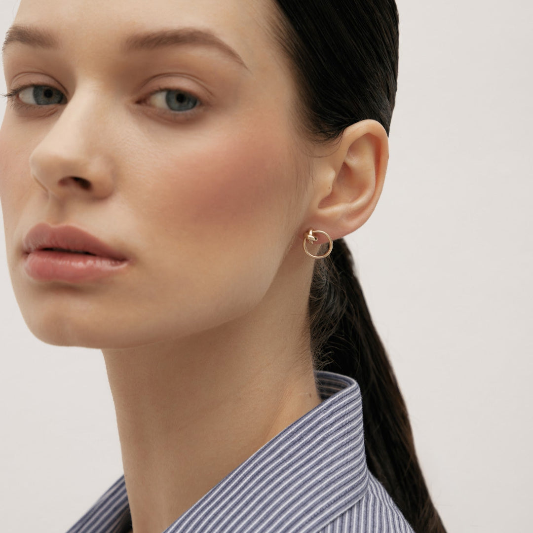 Gold earrings in the shape of a circle with a knot